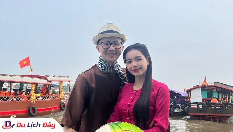 Cặp đôi mặc áo bà ba chụp ảnh lưu niệm trên sông trong Tour Chợ Nổi Cái Răng - Cần Thơ