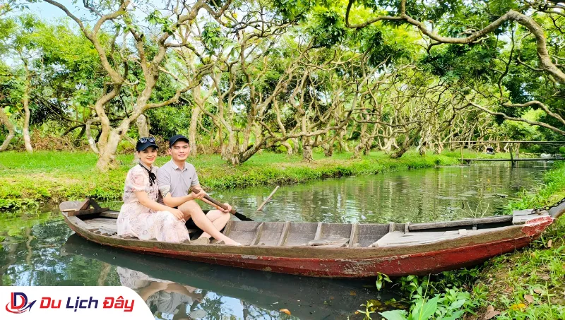 Cặp đôi du khách chèo xuồng giữa rạch nhỏ miệt vườn trong Tour Chợ Nổi Cái Răng - Cần Thơ