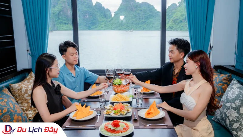 Nhóm du khách thưởng thức tiệc tối sang trọng và nâng ly chúc mừng trong Tour Du thuyền Vịnh Hạ Long 4 sao