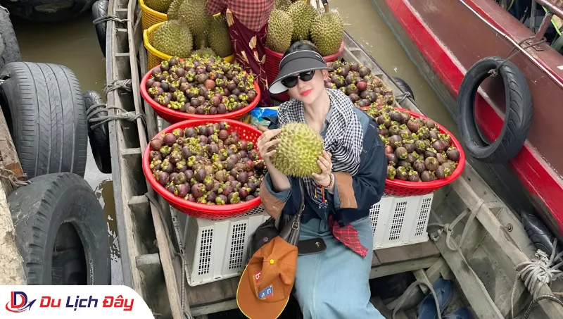 Du khách trải nghiệm mua trái cây tại Chợ Nổi Cái Răng trong Tour Miền Tây 2N1Đ