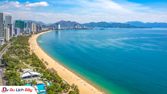 Toàn cảnh vịnh biển Nha Trang góc rộng từ trên cao với bờ cát vàng, làn nước biển xanh ngọc và dãy cao ốc dọc đường Trần Phú