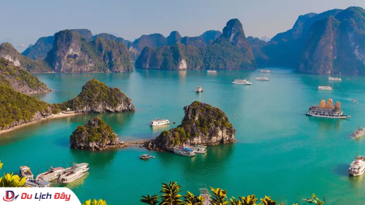 Các hòn đảo đá vôi trùng điệp và du thuyền rải rác trên làn nước xanh ngọc tại Vịnh Hạ Long